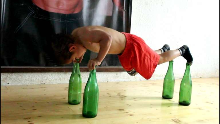 Watch this 5-year-old kid as he does push-up on top of glass bottles