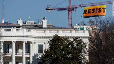 Greenpeace protest Trump by climbing crane near White House and displayed a huge banner that says 'RESIST'